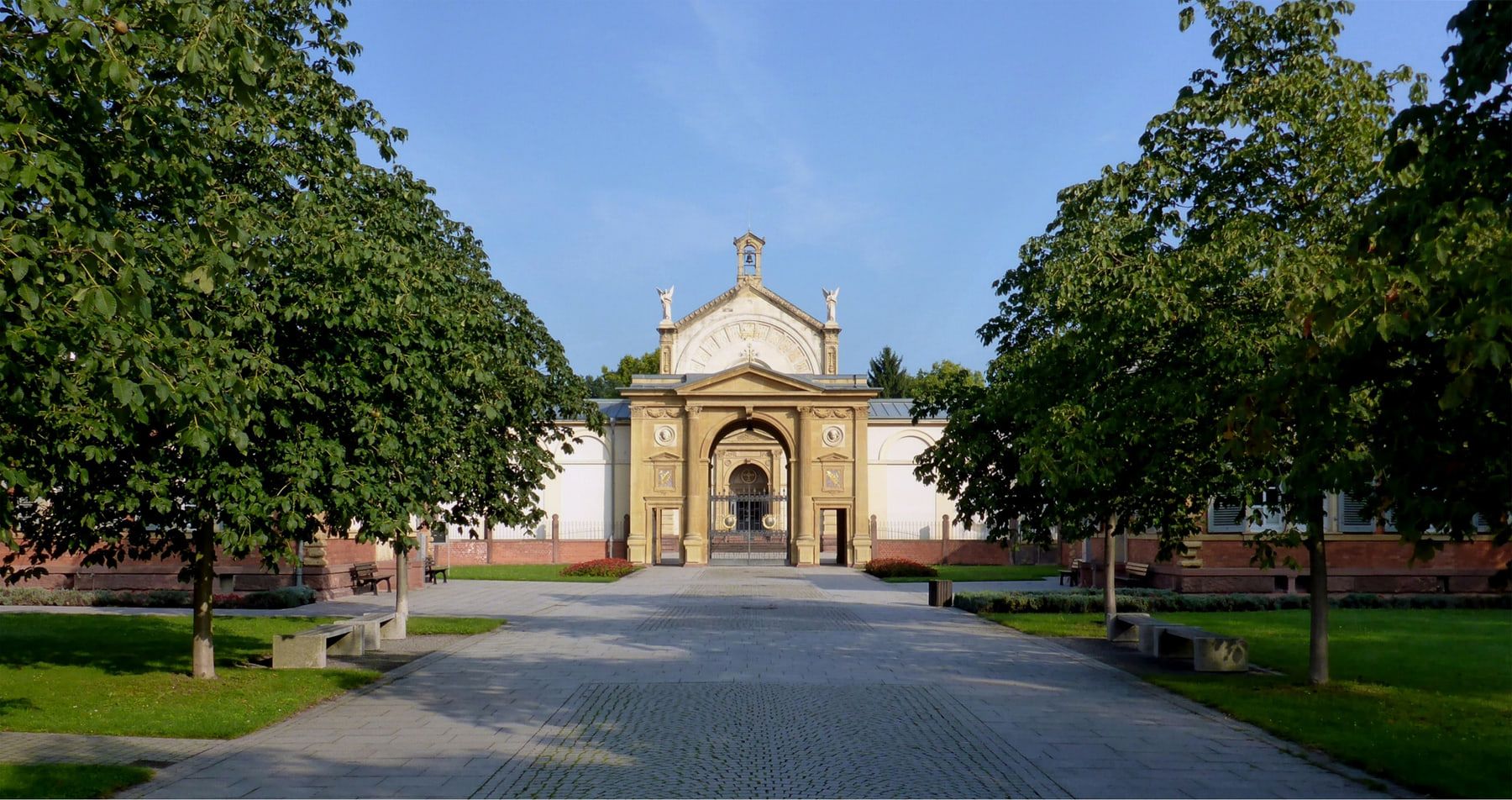 Historisches Eingangsportal am Ende einer symmetrischen, baumbestandenen Achse auf Hauptfriedhof Karlsruhe